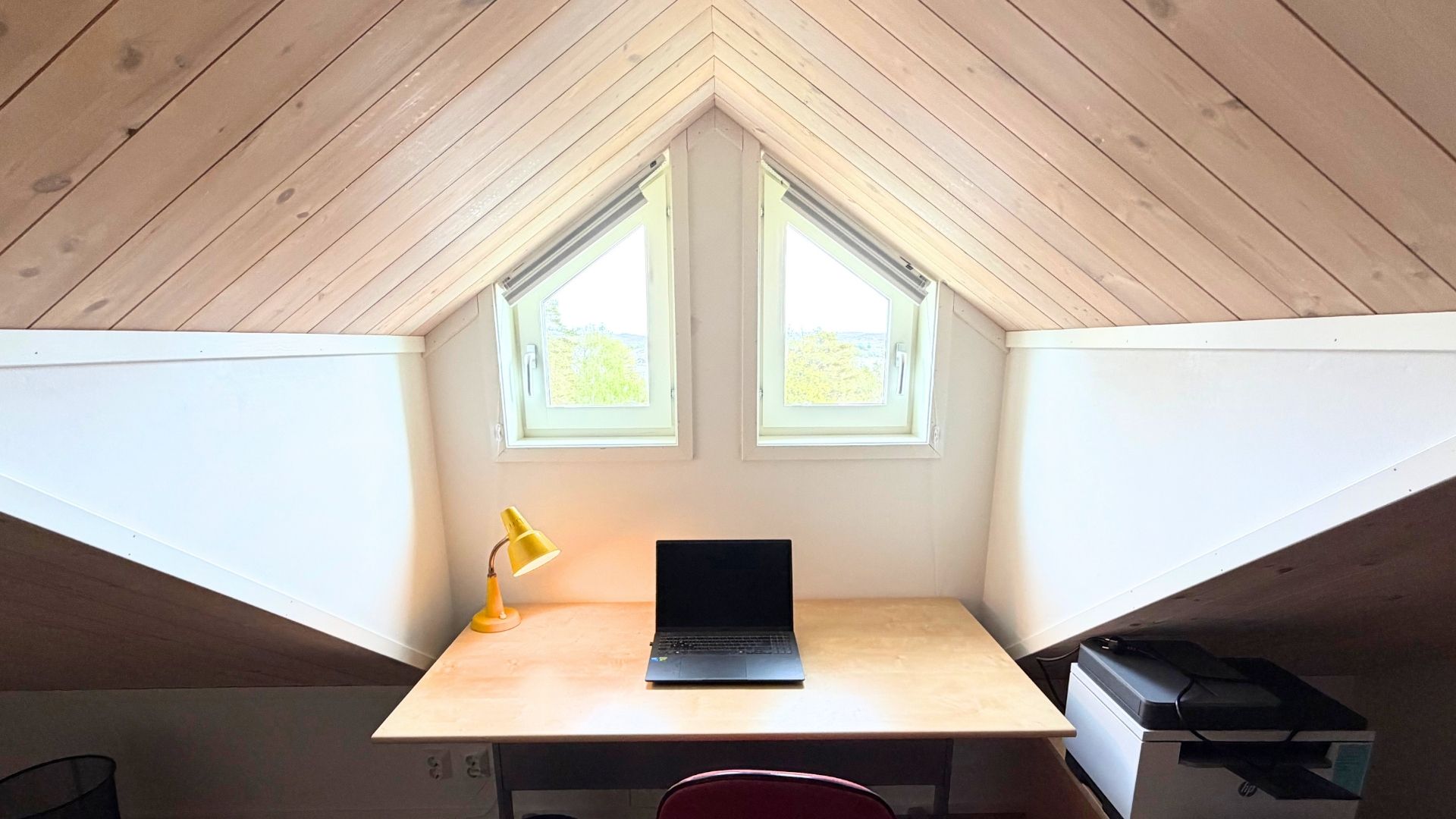 Arbetsplats med skrivbord under snedtak i loftet på Apelgården 81, Tjörn