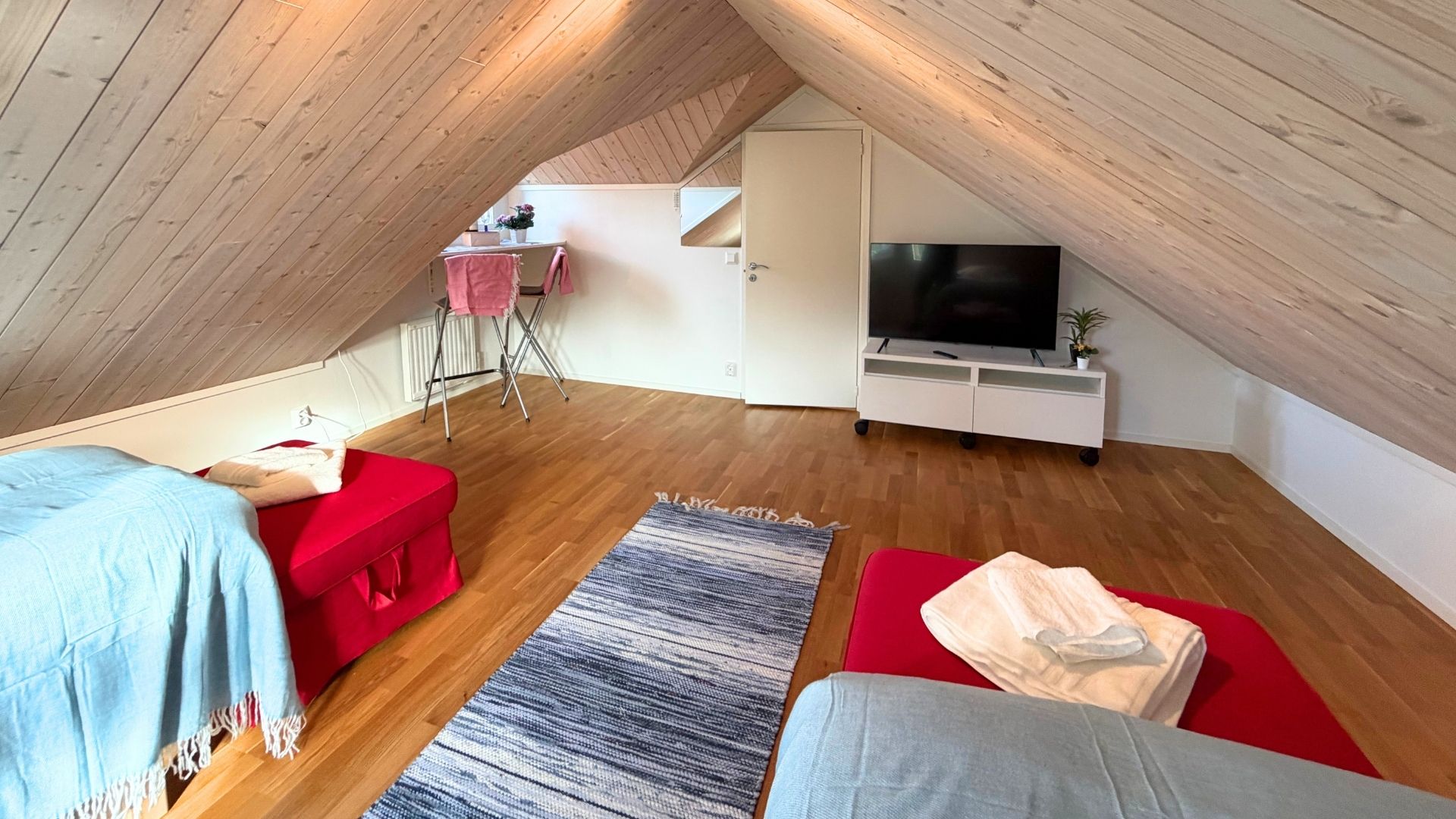 Sovrum 4 i loftet med enkelsängar och TV under snedtak i Apelgården 81, Tjörn