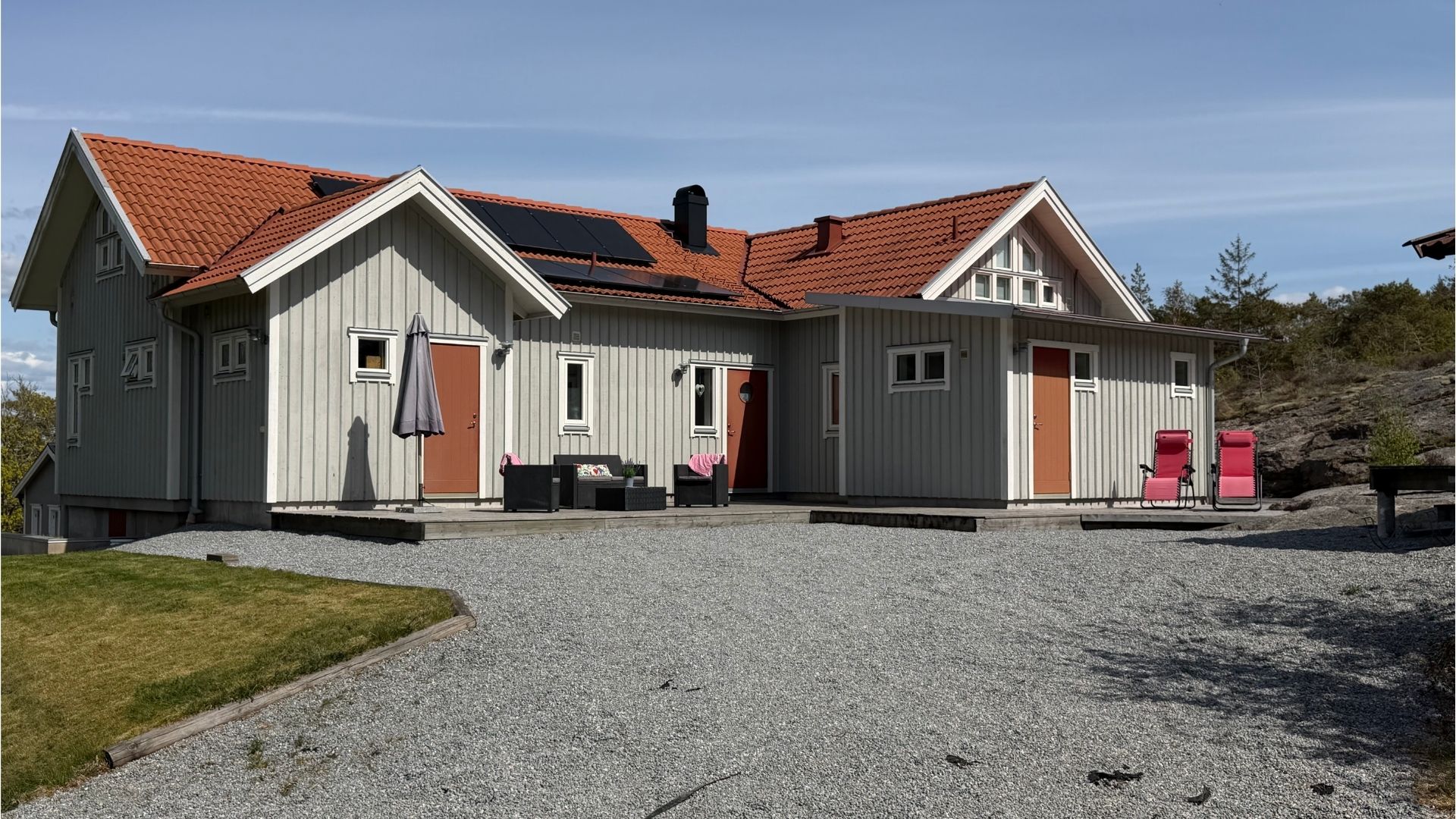 Sommarhuset Apelgården 81 på Tjörn sett söderifrån med stort trädäck och solceller